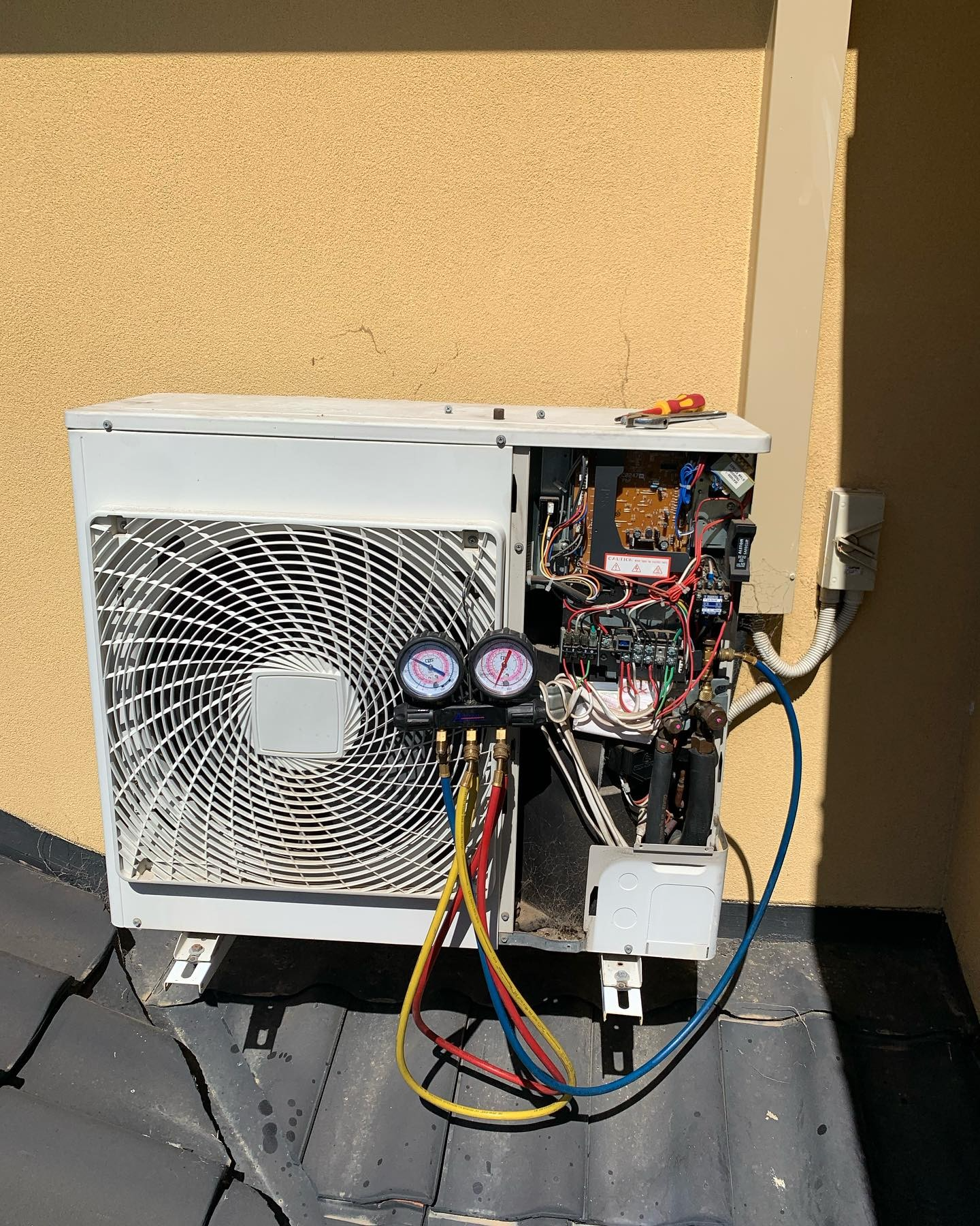 Split system repair using aircon gauges on workshop roof in Wangara Perth WA